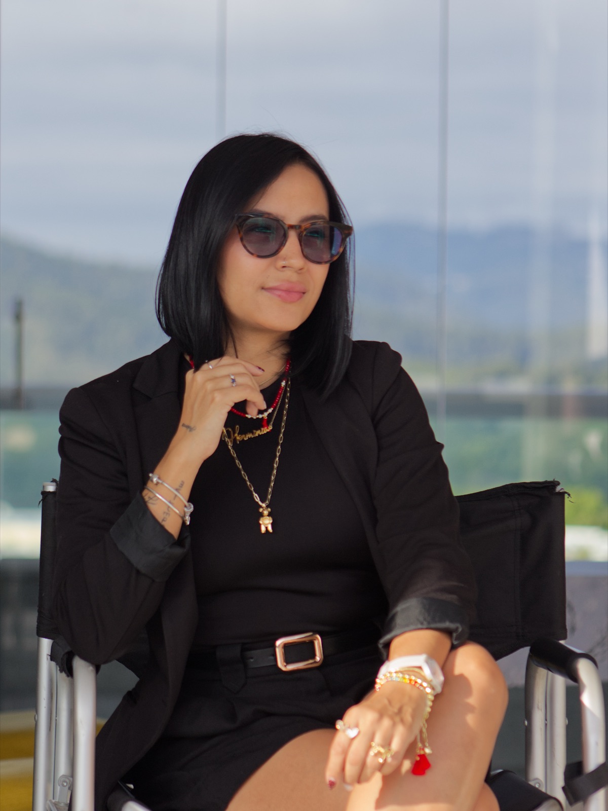 Herminia Abreu, cosmiatra y maquilladora profesional, sentada en una terraza con montañas al fondo